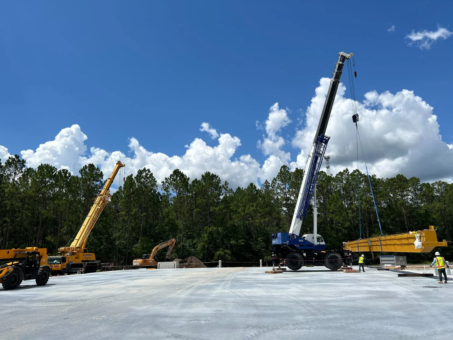 Crane lifting steel beam at a construction