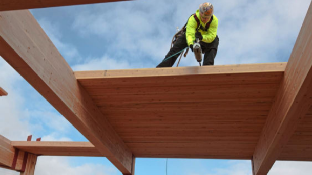 Mass Timber Construction with Worker on top of beams